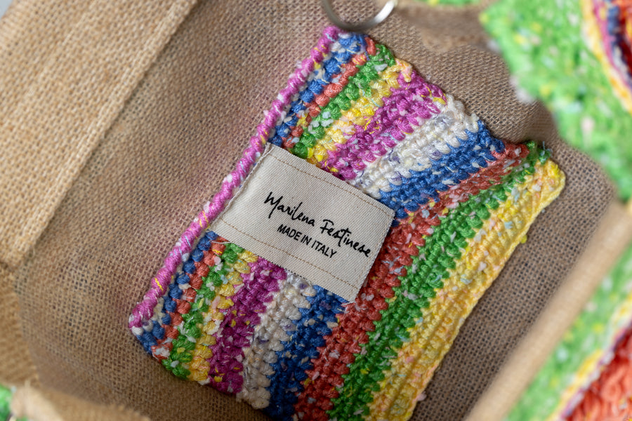 Una composizione di righe di filati diversi lavorati ad un uncinetto, regalano un lavoro unico pieno di allegria. I manici in bambù, uno dei simboli identificativi del brand, permettono di indossarla come borsa a mano; La sua tracolla rimovibile, invece, permette di portare la borsa a spalla. Di manifattura artigianal…